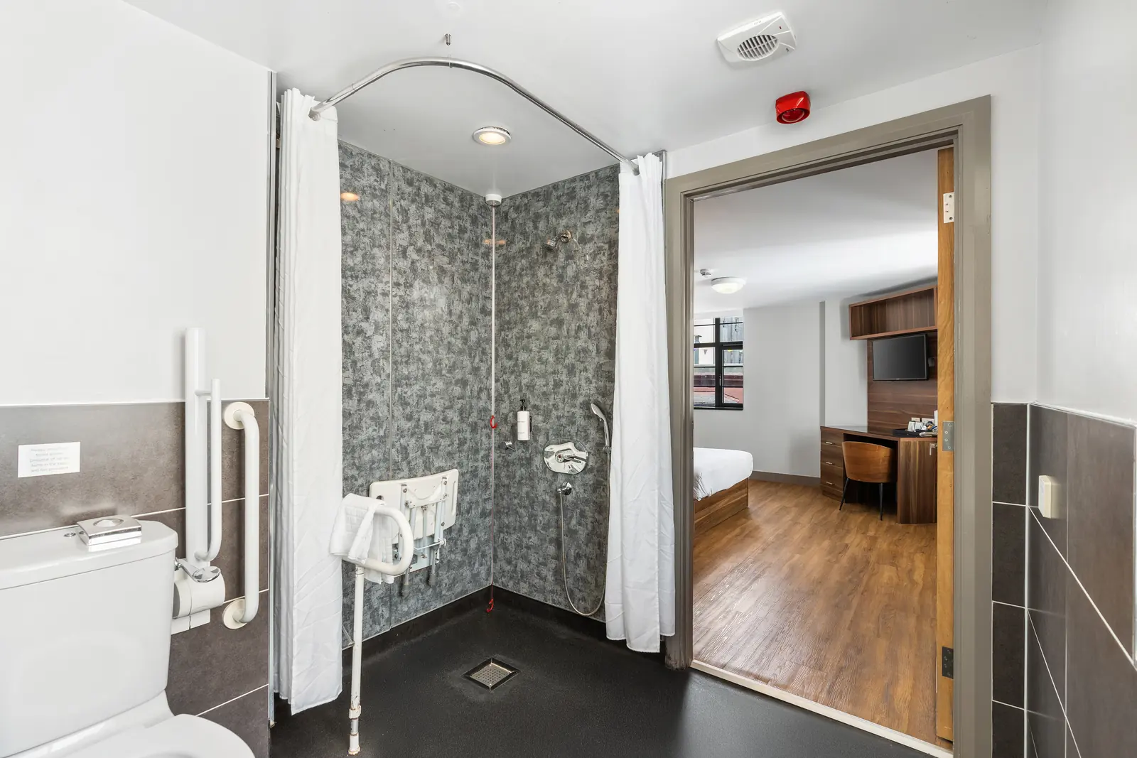 Accessible wet room with roll-in shower and grab rails