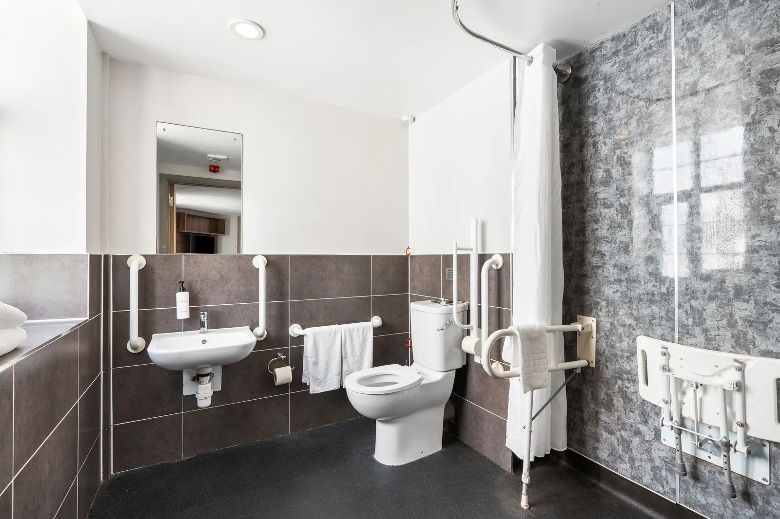 Accessible bathroom with support rails and shower seat